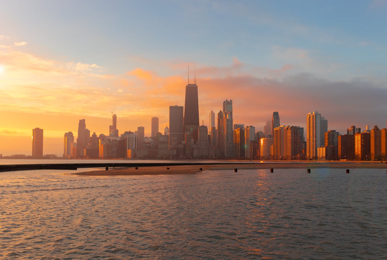 about-us Stunning view of the Chicago skyline at sunset reflecting over Lake Michigan's calm waters.
