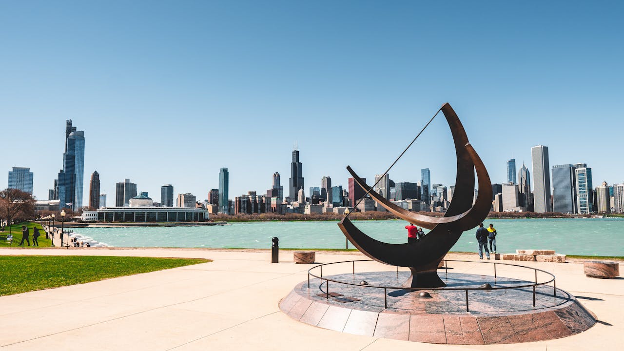 services-06 A scenic view of Chicago skyline from the waterfront with modern architecture and a striking sculpture.