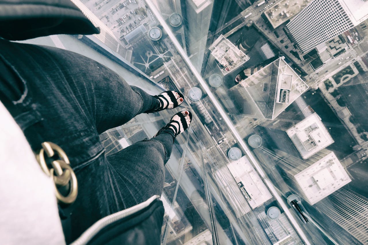 why-choose-us View from a glass platform showcasing skyscraper rooftops in Chicago from above.