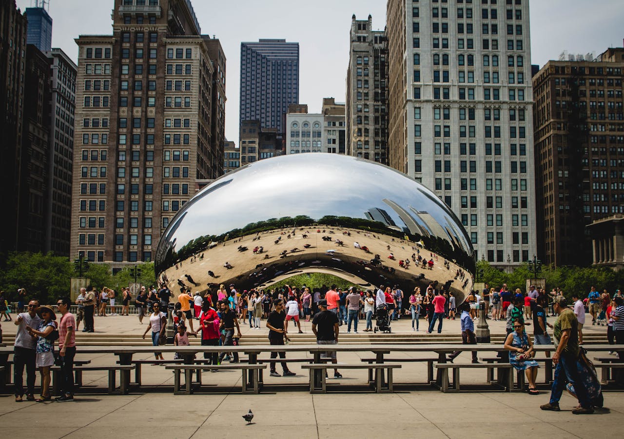 services-bg People gathering around Cloud Gate in Chicago with reflections of cityscapes. Popular tourist spot in Millennium Park.